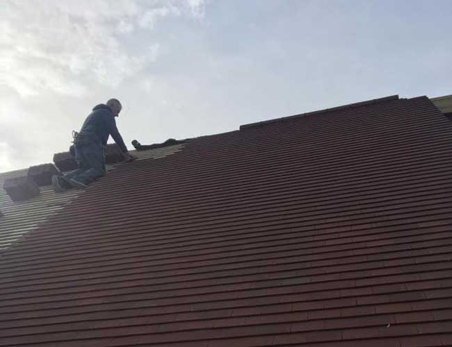 Man laying tiles on a roof in Kent