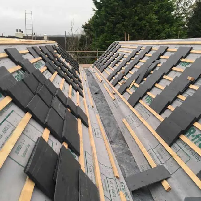 Natural slate tiles stacked on a new roof ready for installation